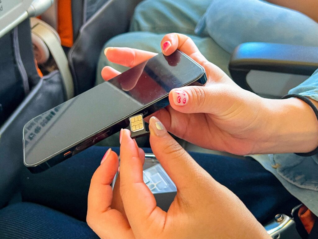 Traveler inserting a SIM card into a smartphone