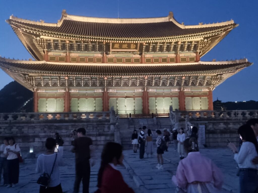 Gyeongbokgung Palace at night with visitors in the palace courtyard