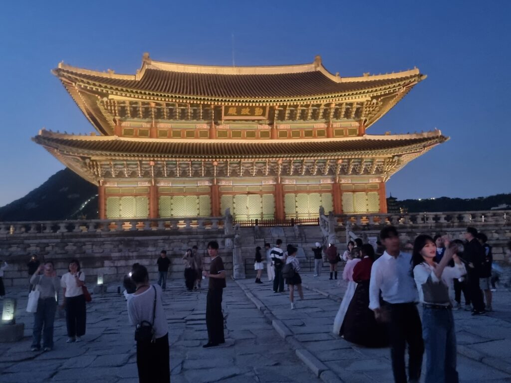 Gyeongbokgung Palace illuminated at night with visitors in the palace courtyard