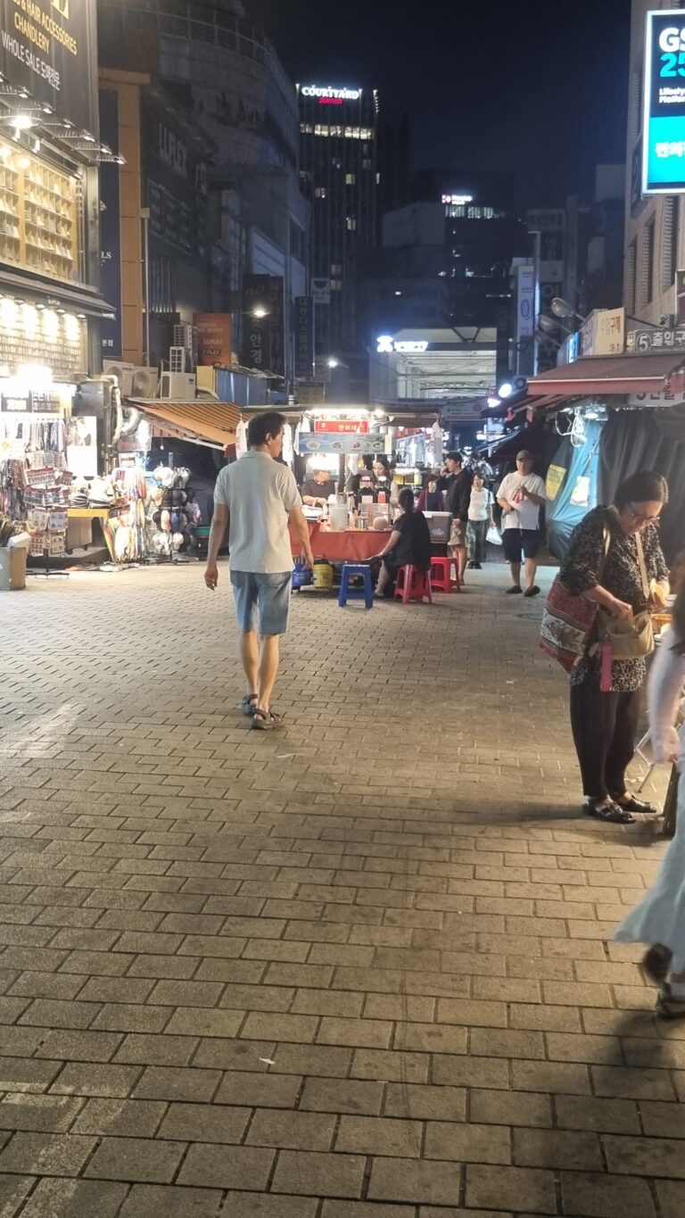 Namdaemun Market street at night with food stalls, shops, and pedestrians in Seoul