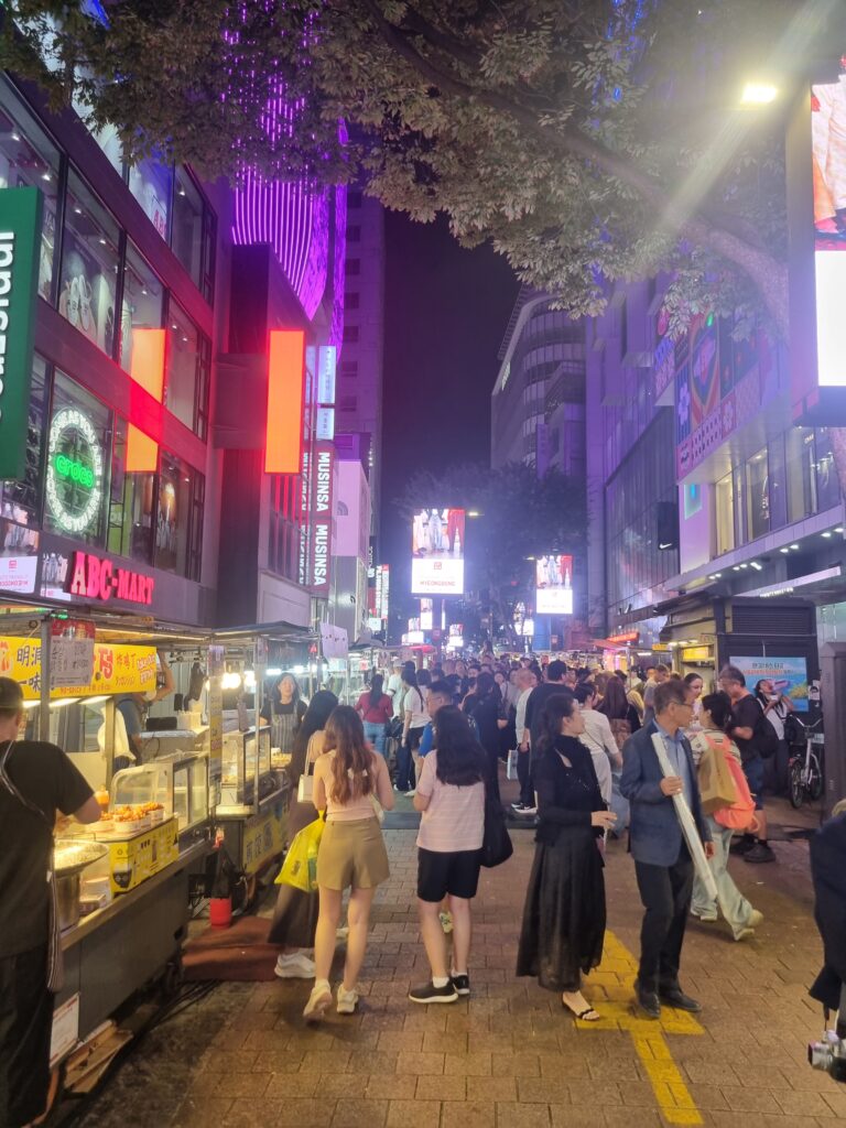 Myeongdong night street with food stalls, shops, and crowds in Seoul