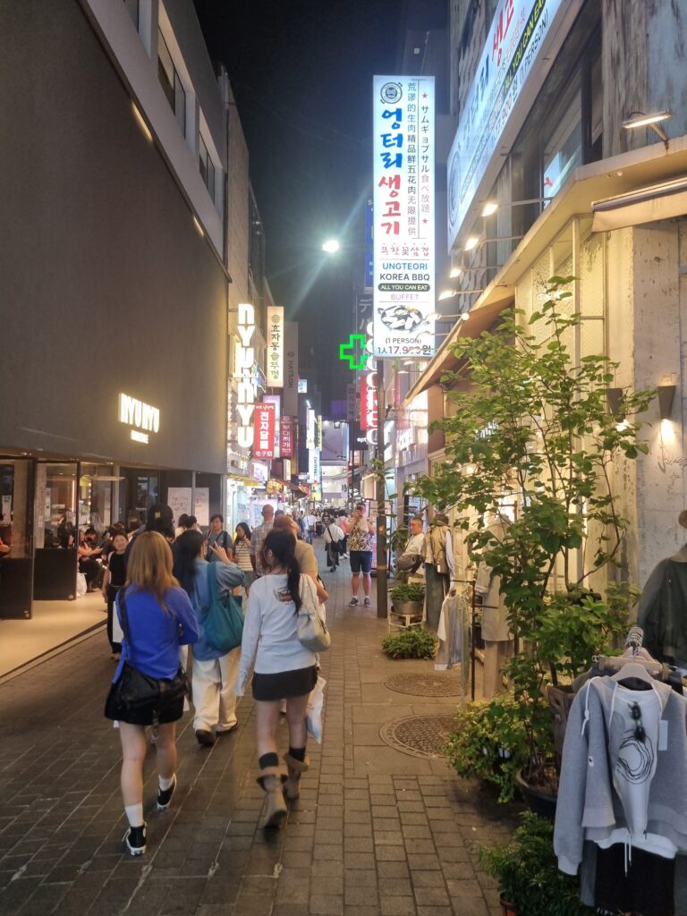 Myeongdong street in the evening with shops, pedestrians, and illuminated signs in Seoul