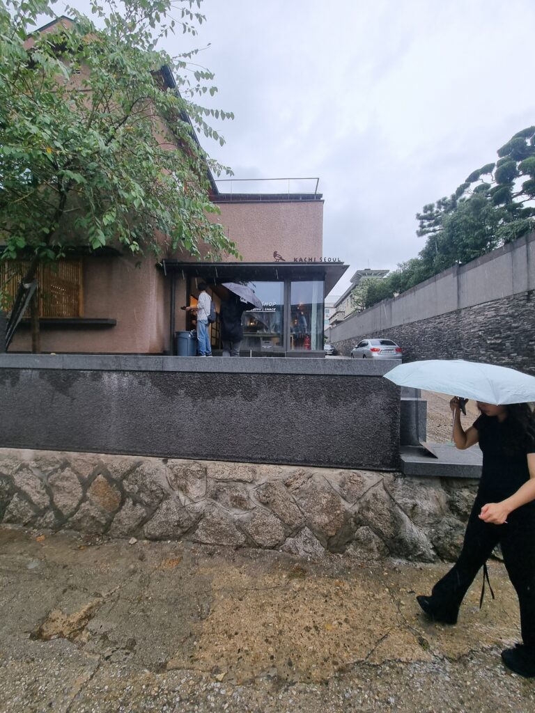 Traditional residential street and stone wall in Bukchon Hanok Village on a rainy day