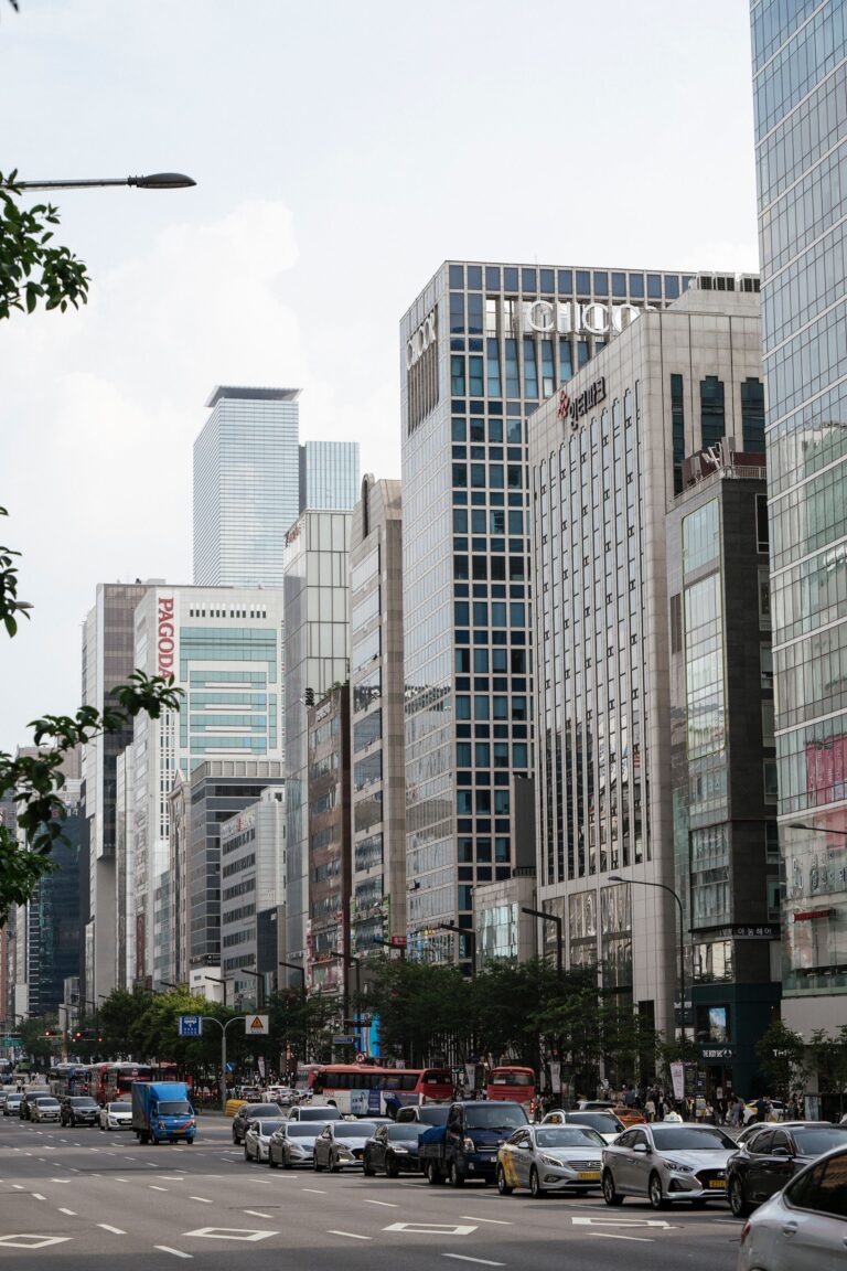 A busy city street with tall modern buildings and traffic in Gangnam, Seoul