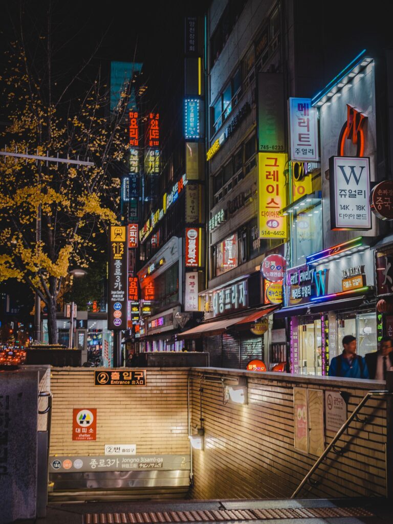 Jongno 3-ga subway station entrance and busy shopping street at night in Seoul