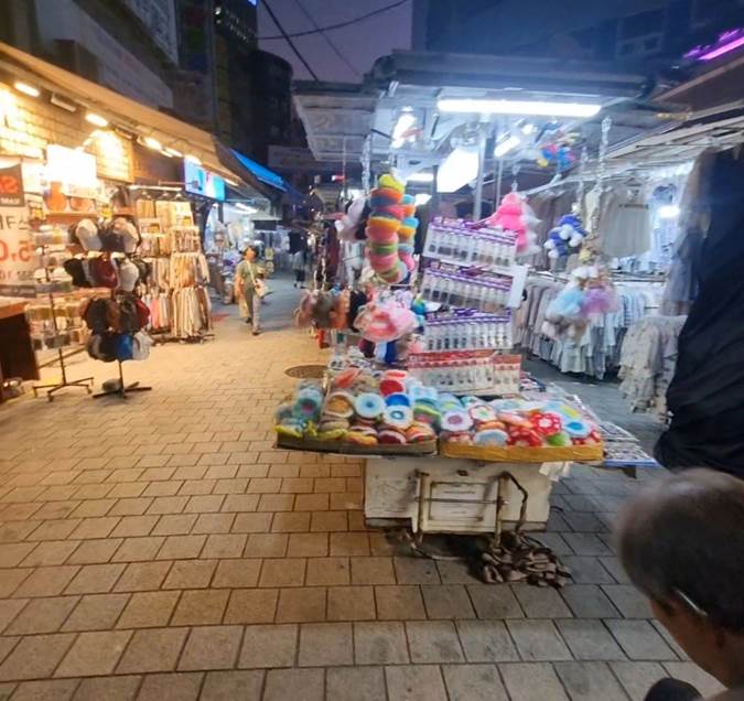 Namdaemun Market evening street with clothing, accessories, and souvenir stalls in Seoul