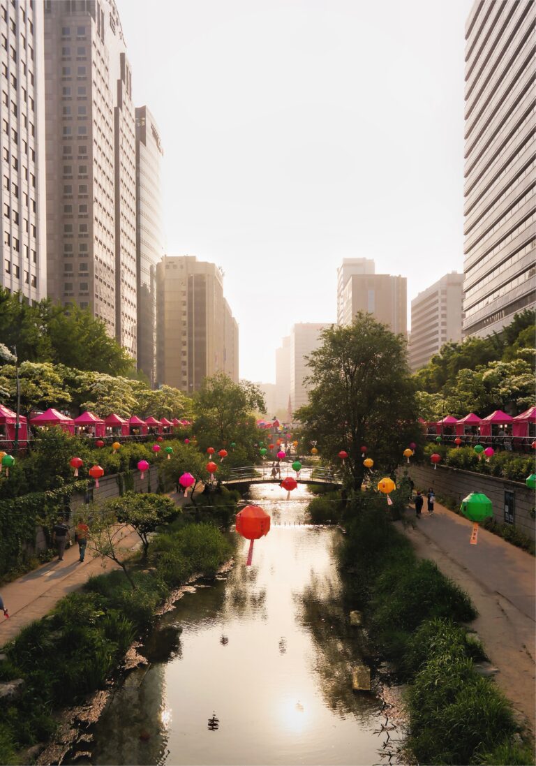 Cheonggyecheon Stream in Seoul decorated with colorful lanterns, walking paths, bridges, and surrounding city skyscrapers